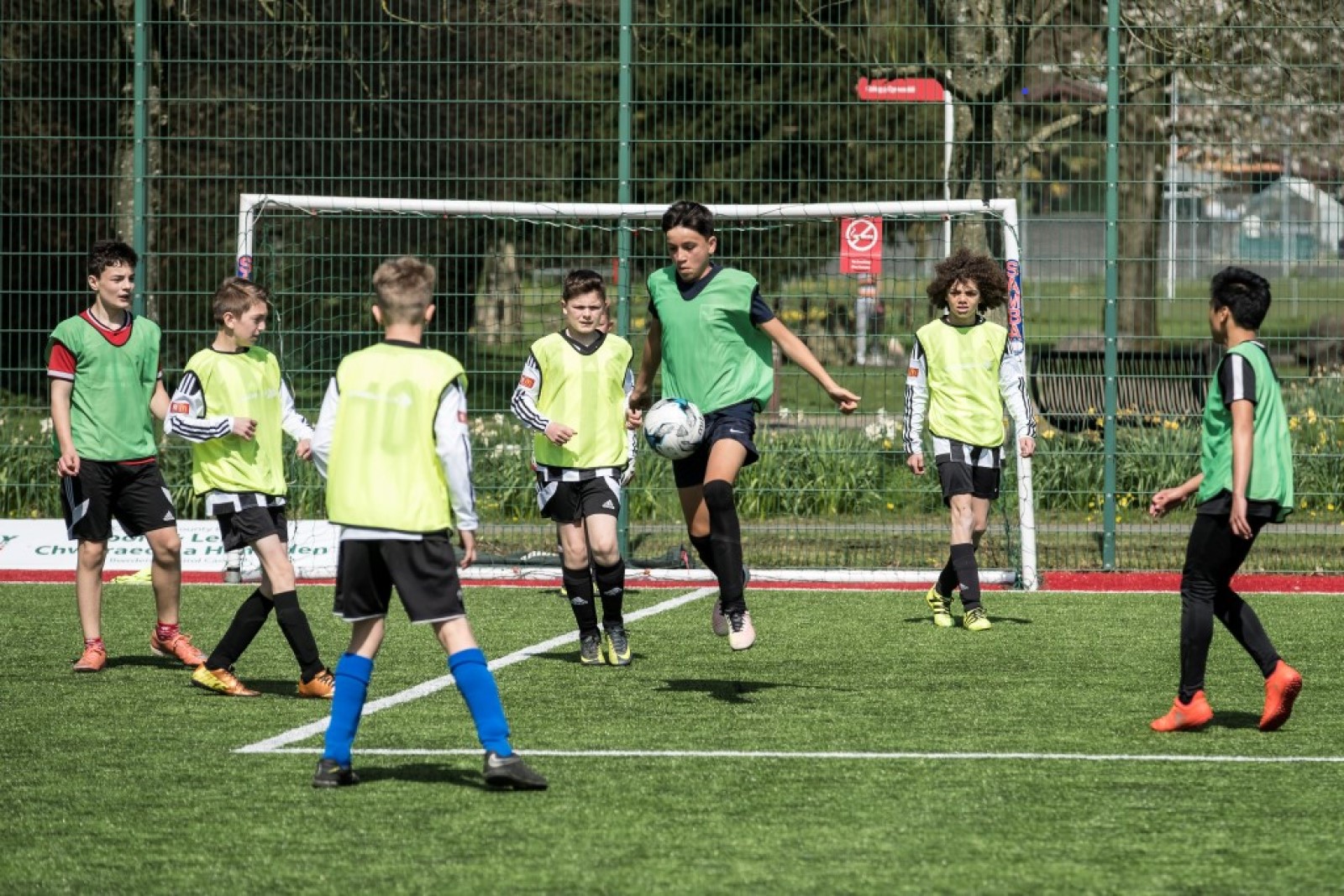 Children playing football on an outdoor pitch.jpg